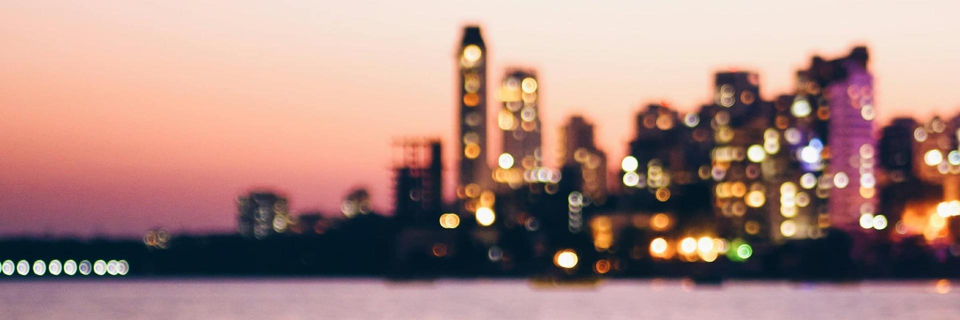 Mumbai skyline across the sea at dusk, out of focus